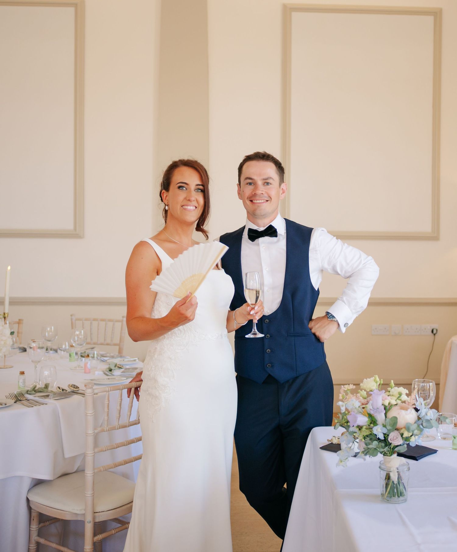 Wedding reception venue with elegant white decor and floral arrangements.