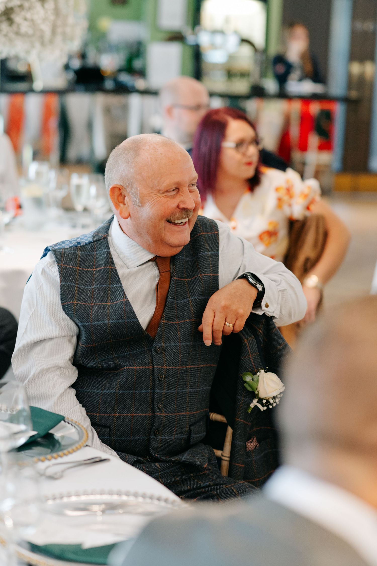 Wedding guest enjoying the reception dinner and conversation at a decorated table.