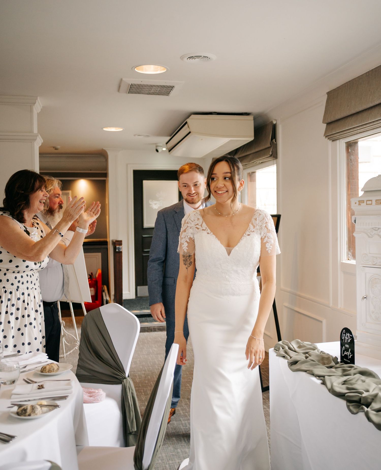 A celebration scene in a bright indoor venue with formal attire and table settings.
