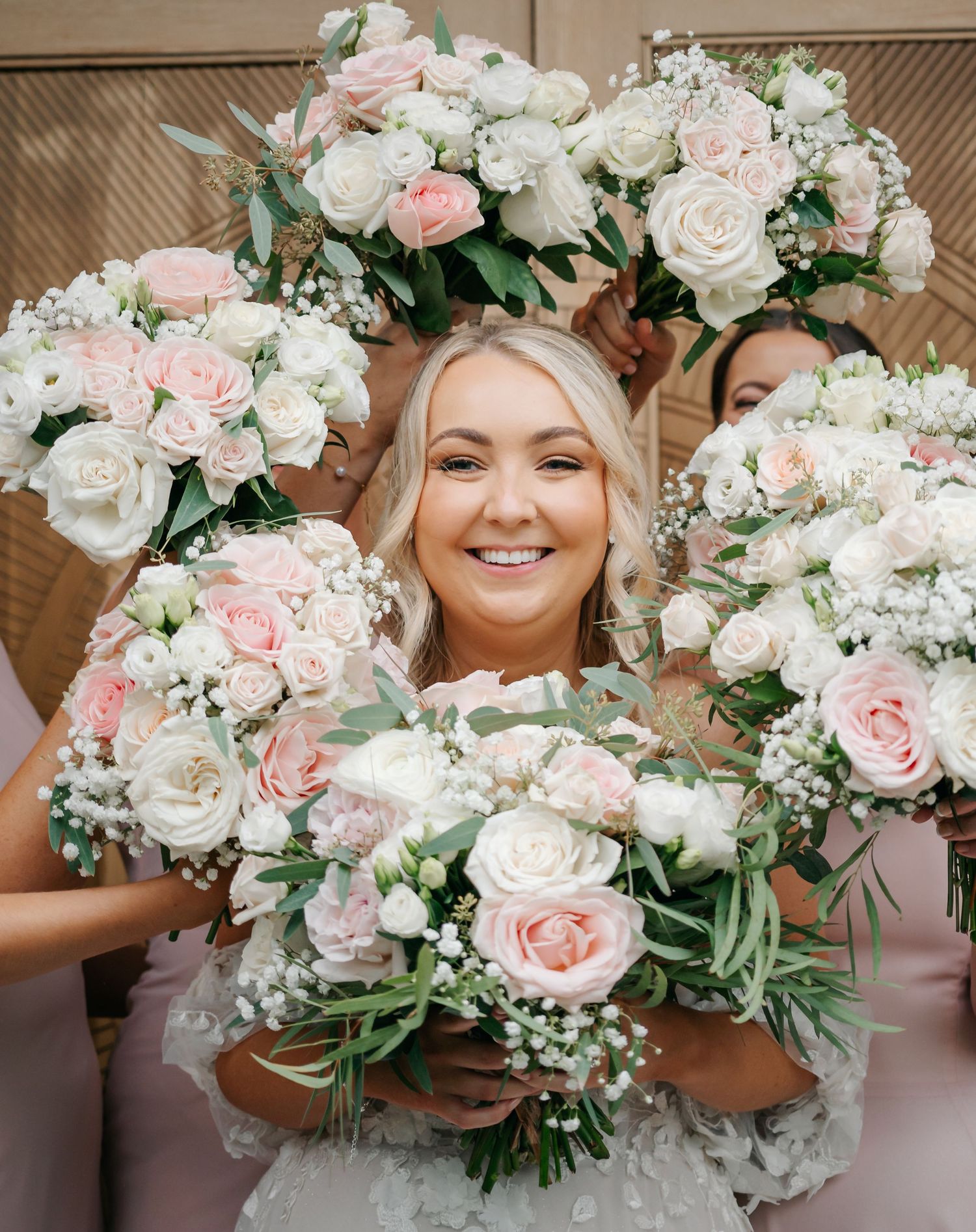 Collection of romantic blush pink and white wedding bouquets with roses and baby's breath.