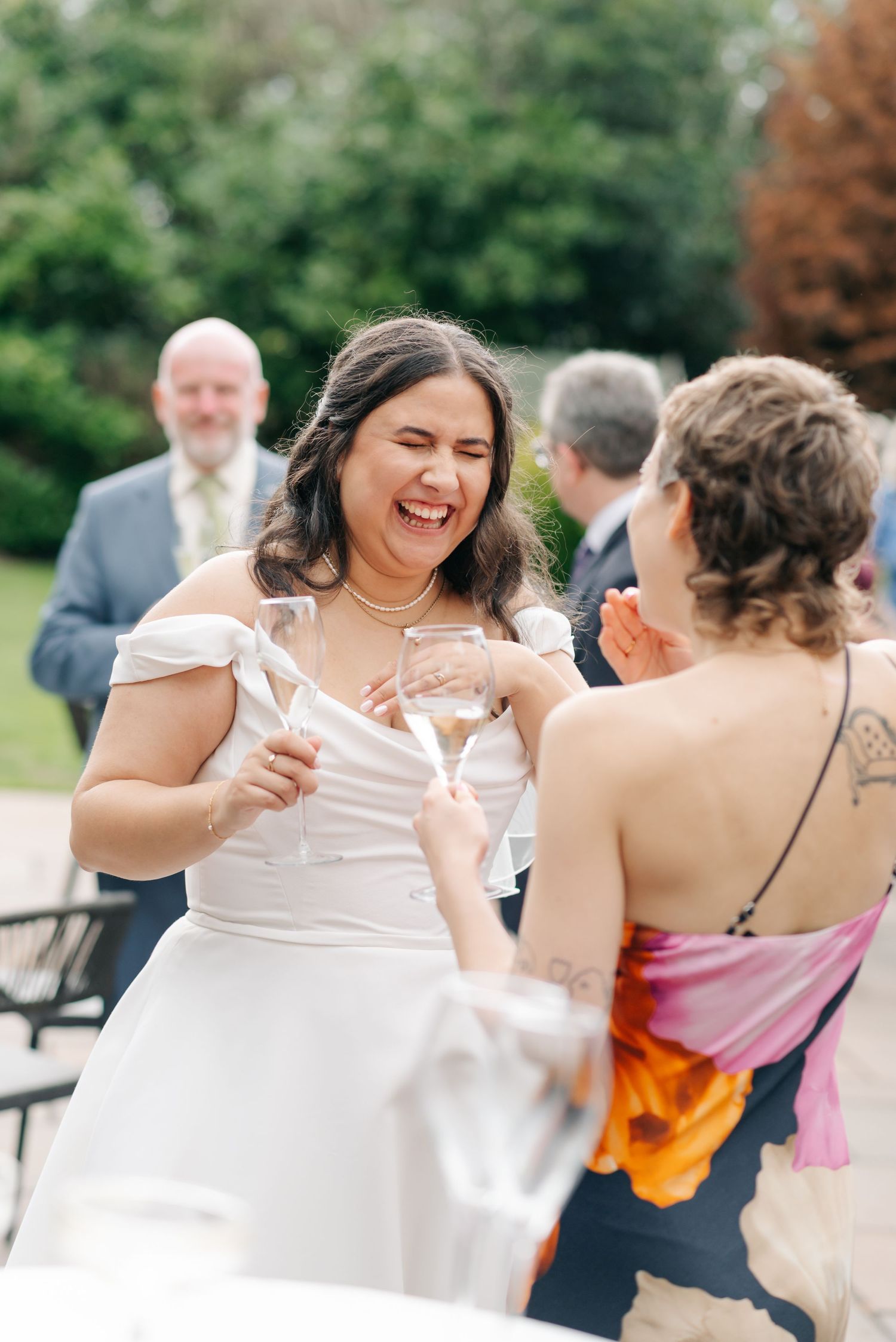Wedding guests share laughter and dance together during outdoor reception celebrations.