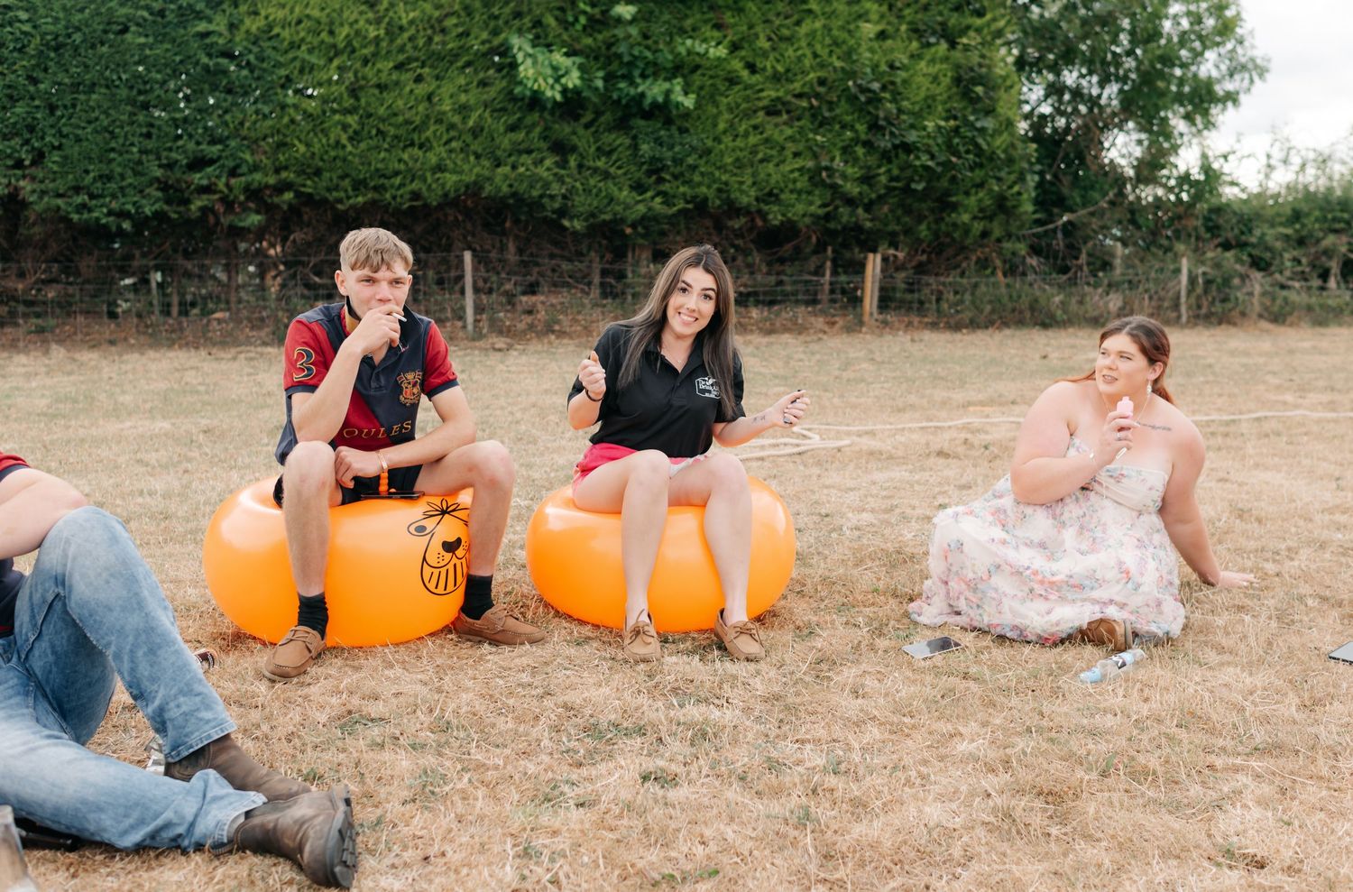 Wedding guests lounging on grass with orange pumpkins creating festive outdoor atmosphere.