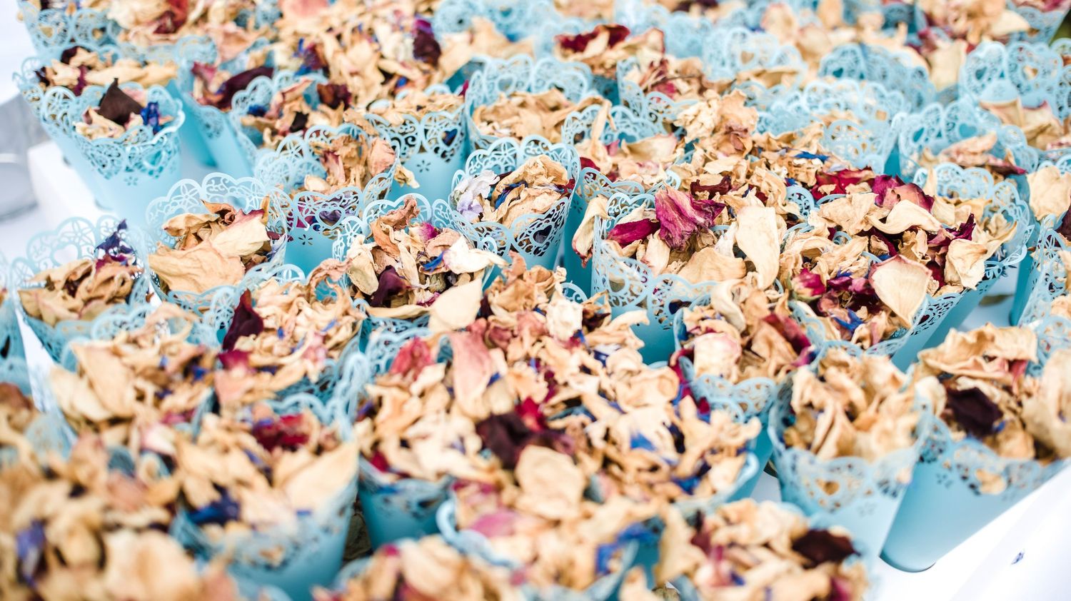 Close-up of blue and pink confetti scattered on a surface creating a festive texture pattern.