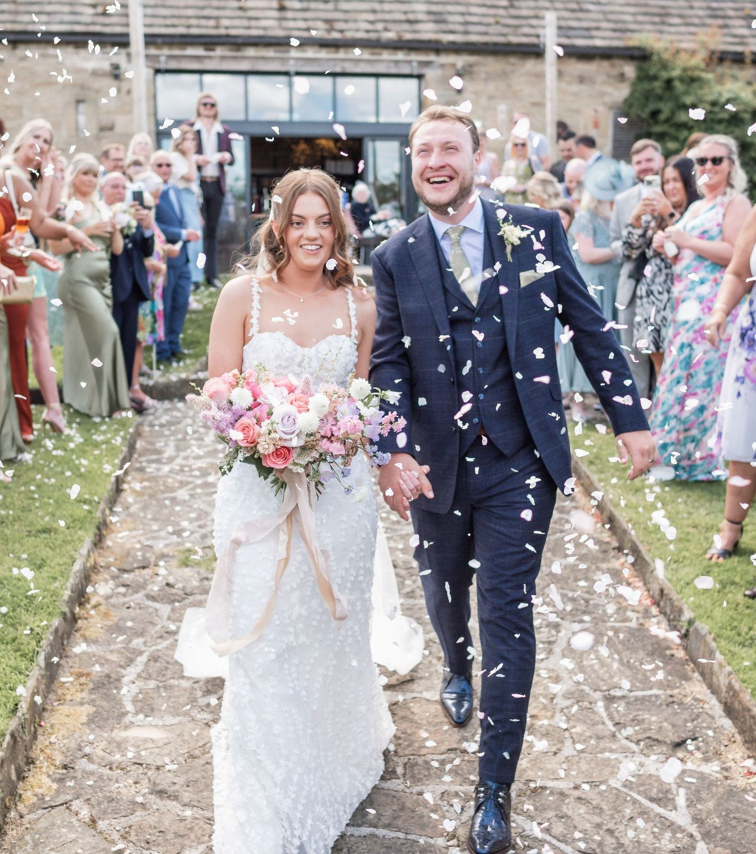 A celebratory moment with confetti flying during an outdoor wedding ceremony.