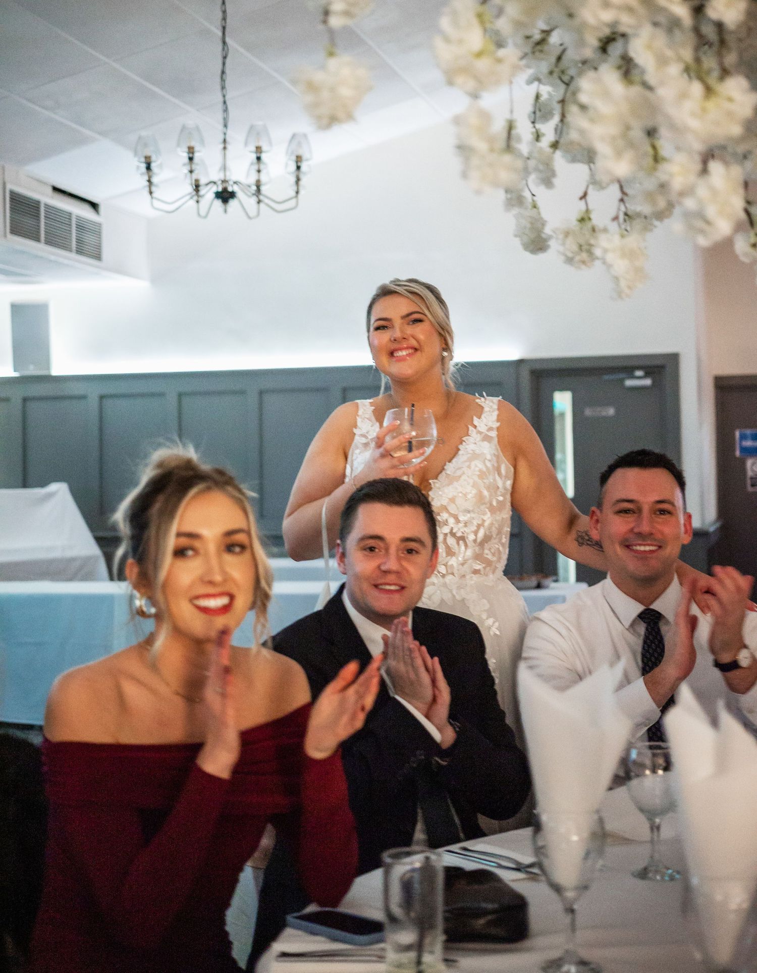 Wedding reception guests and attendees applauding during a celebration.