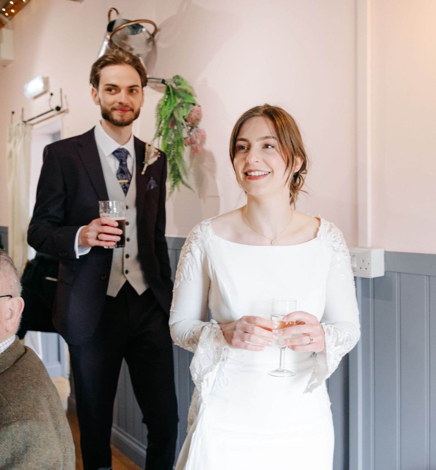 Wedding party members in formal attire gather for candid moments during celebration.