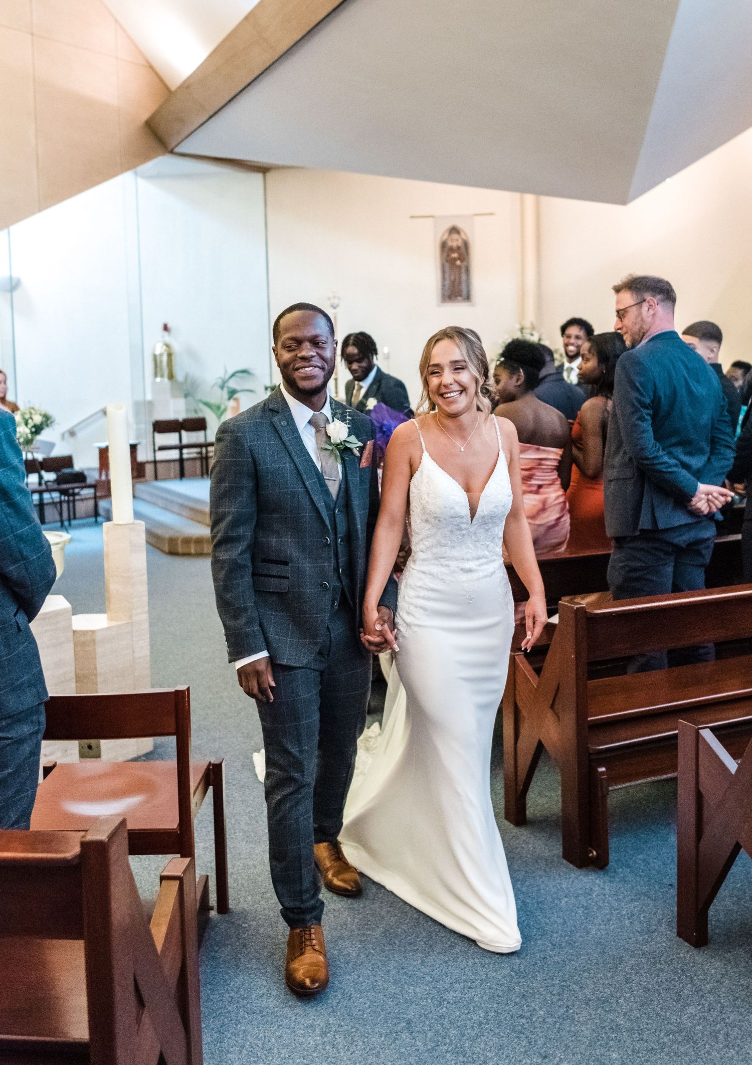 A newlywed couple walks down the church aisle together after their ceremony.