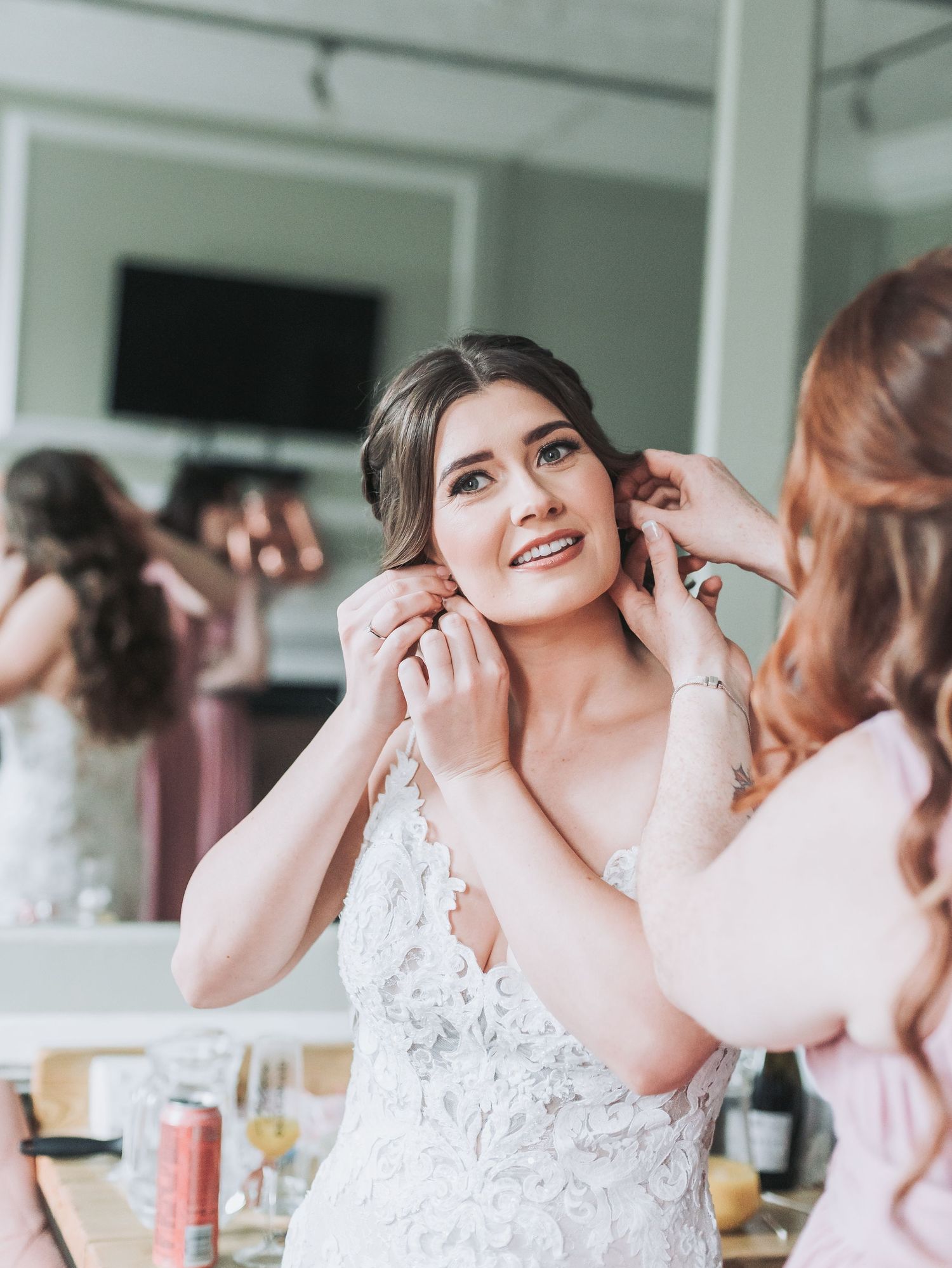 Someone in a lace wedding dress getting final touches during wedding preparations.
