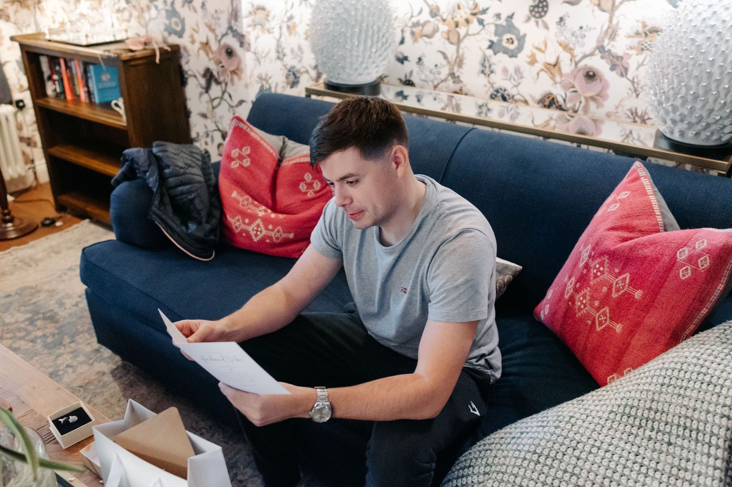 Person sitting on couch using laptop computer while working from home in casual environment.