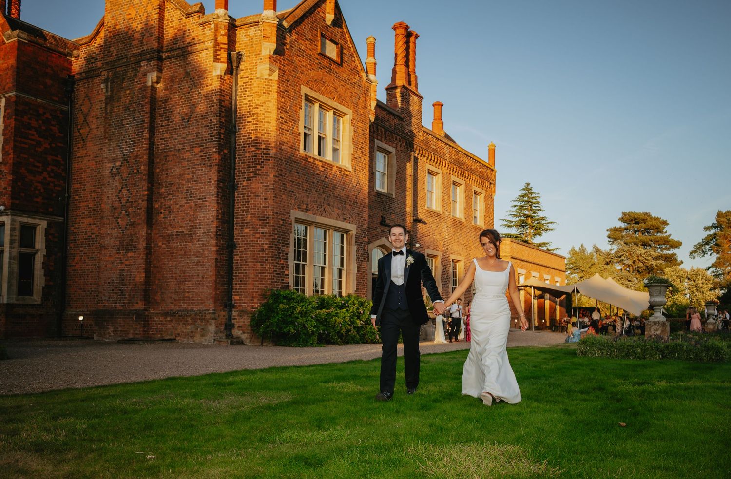 Historic brick building exterior with manicured lawn at sunset.