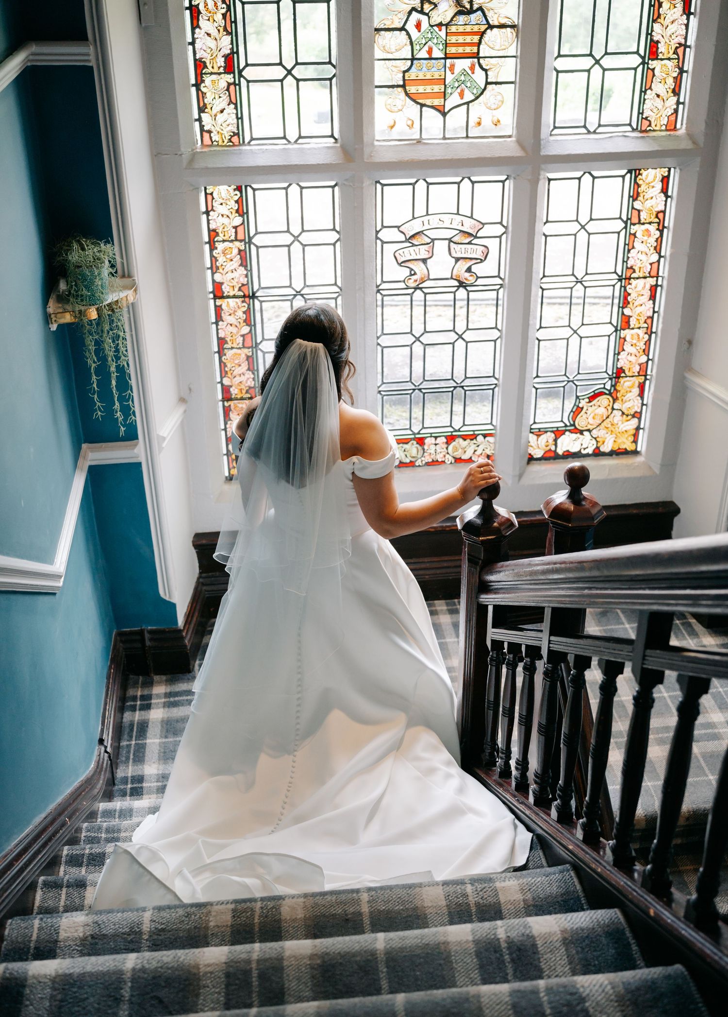 White wedding dress flowing gracefully in front of stained glass windows.