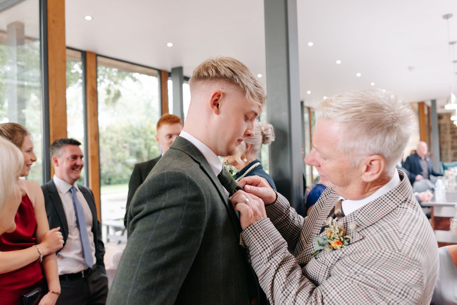 Tender moment during wedding preparations in a modern indoor setting.
