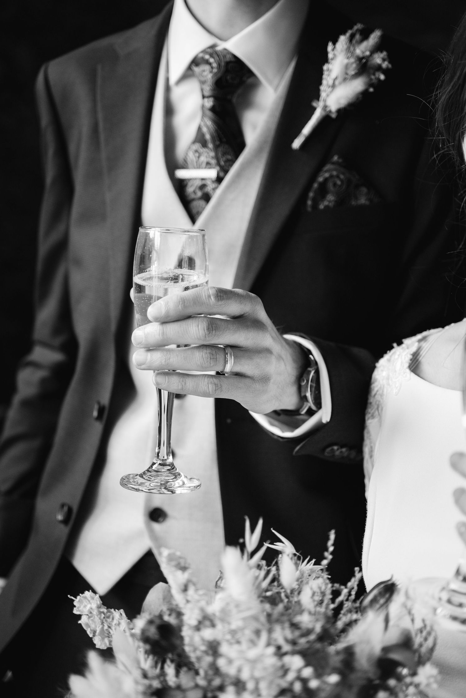 Close-up black and white shots of wedding guests holding champagne glasses during toasts.