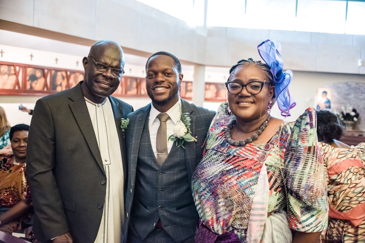 Three people in formal attire share a joyful moment at a celebratory event.
