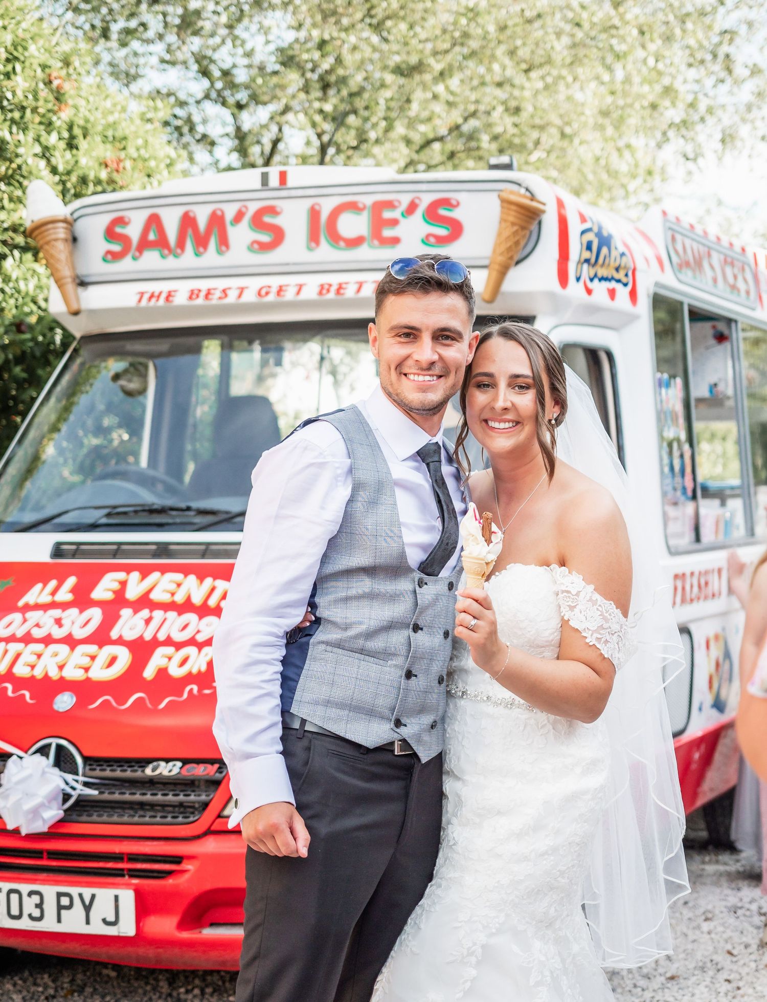 Couple posing with ice cream in front of Sam's Ice's vintage food truck.