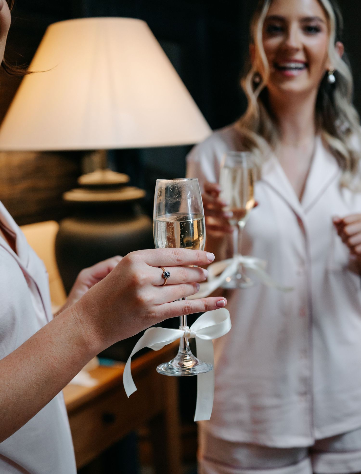 Close-up shots of hands holding champagne glasses during a wedding celebration.