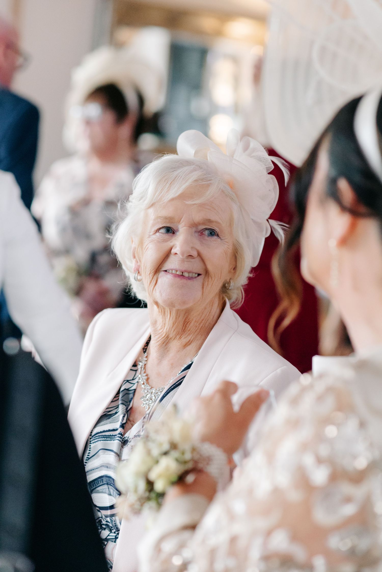 Wedding guests sharing joyful moments during an elegant indoor celebration.