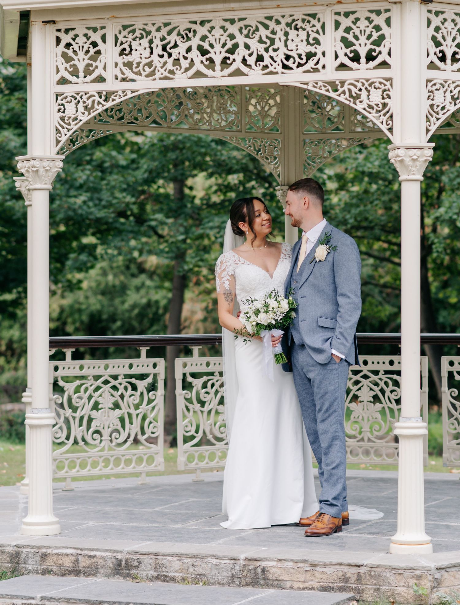 Elegant white gazebo provides romantic backdrop for wedding portraits.