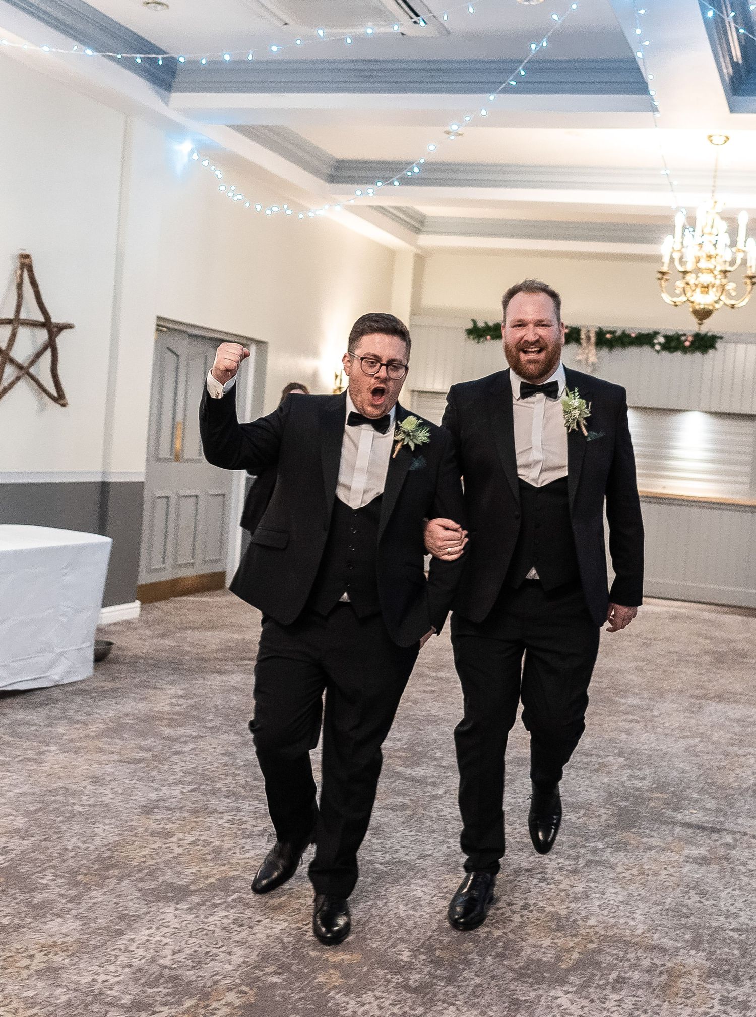 Celebration in elegant ballroom with coffered ceiling and twinkling lights.