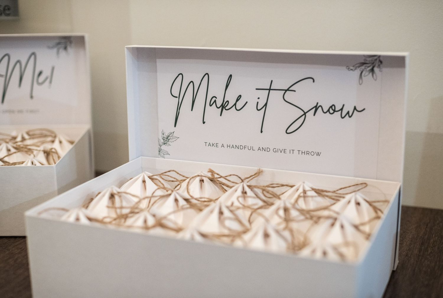 White box of delicate meringue treats with 'Make it Snow' text displayed on elegant signage.