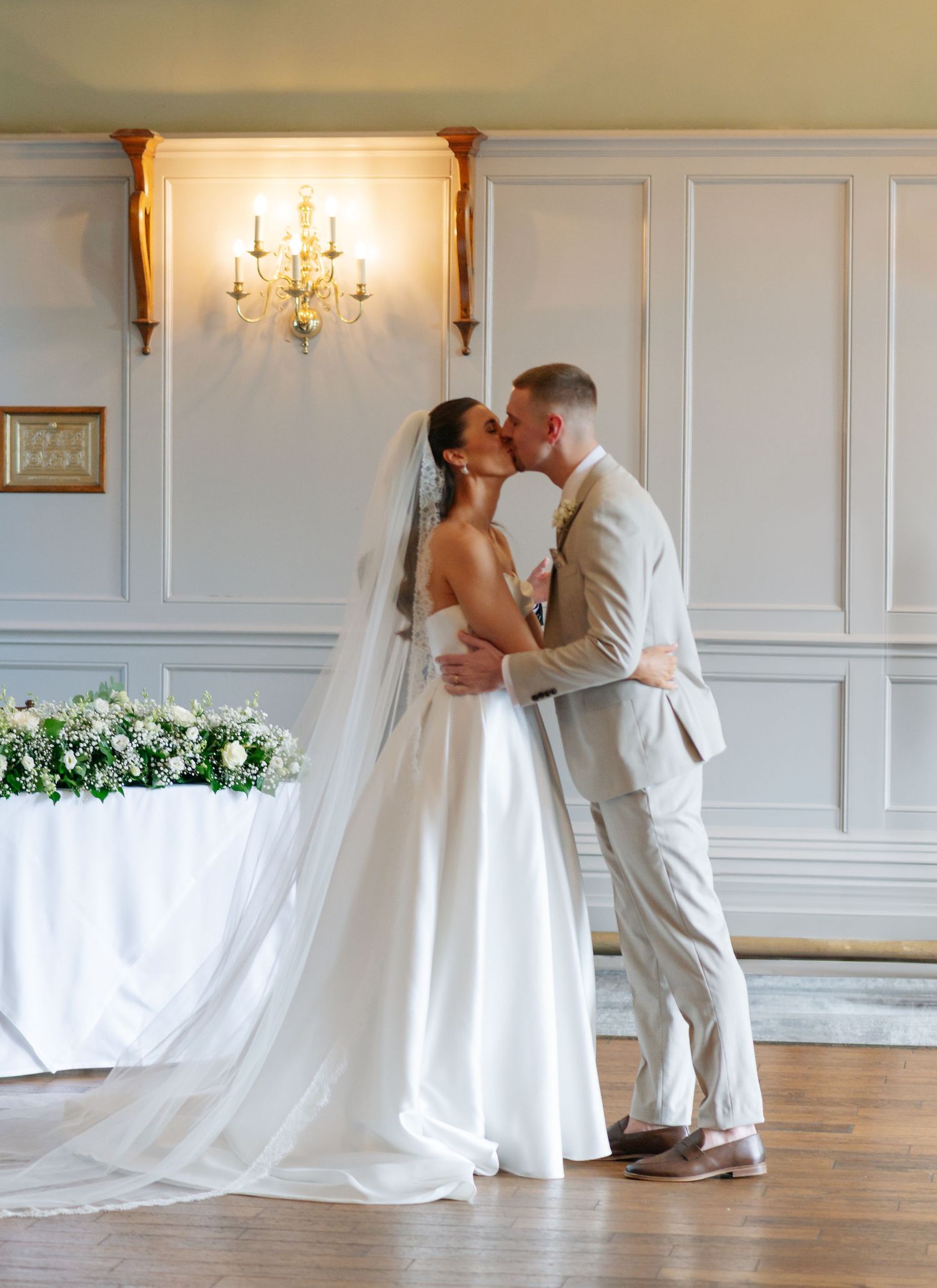 A romantic first look sequence between a couple in an elegant white-paneled room with a bride in a flowing gown.