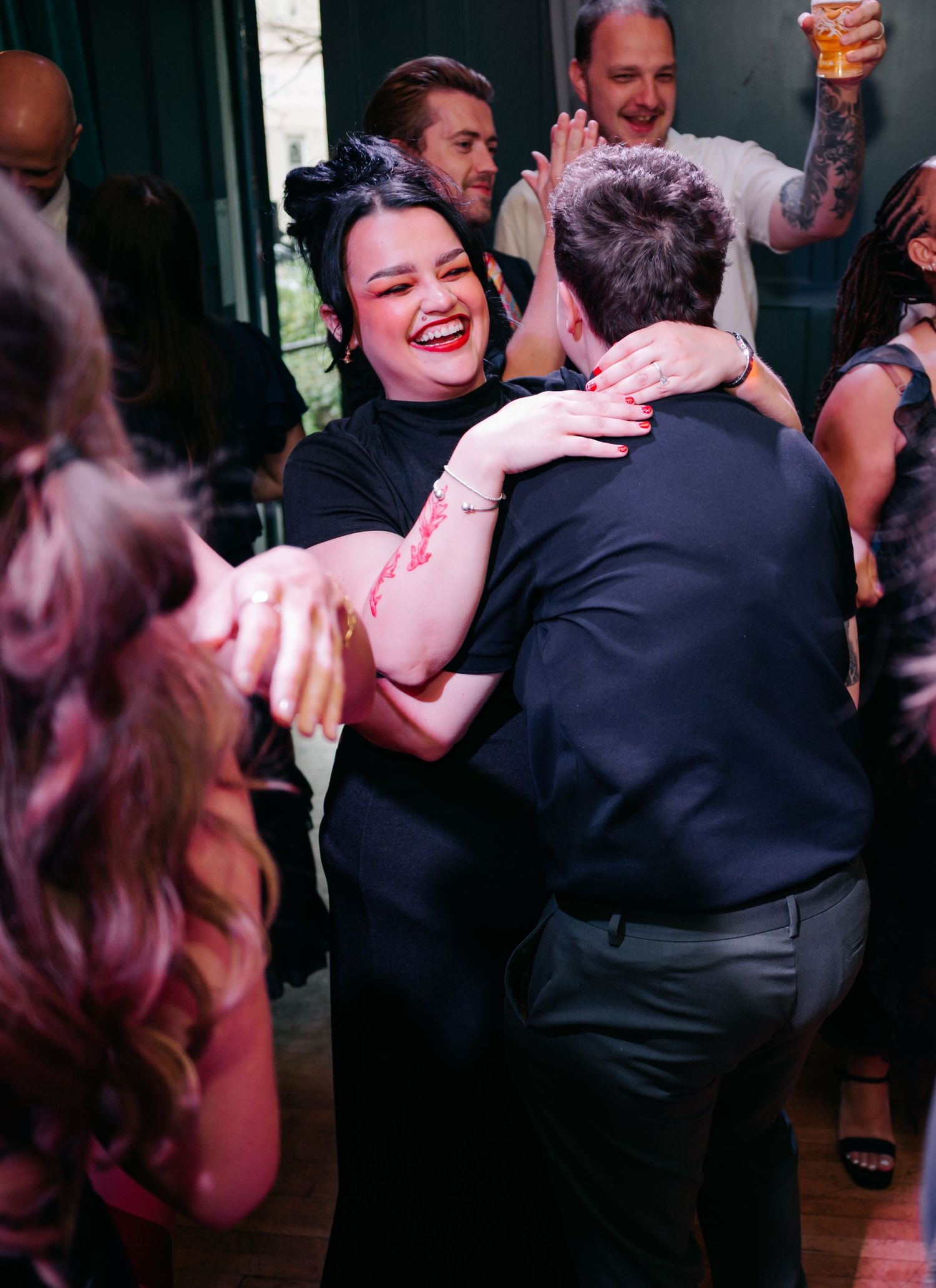 Wedding guests share laughter and dance together during the reception celebration.