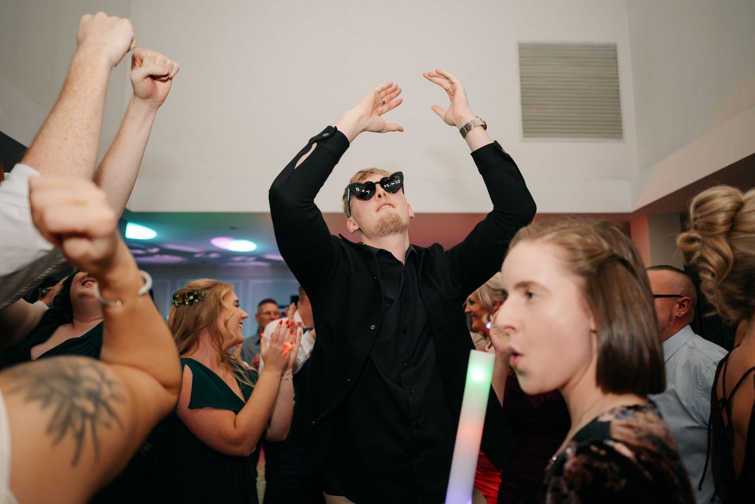 Wedding reception dance party with guests celebrating on the dance floor.
