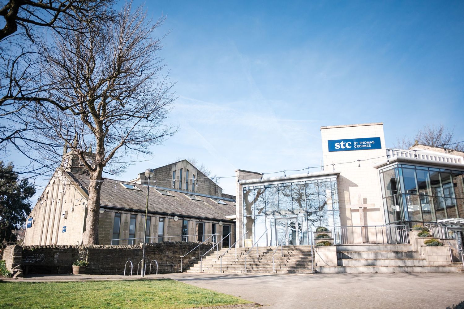 Panoramic sequence showing abandoned and damaged church buildings with bare trees against a bright blue sky.