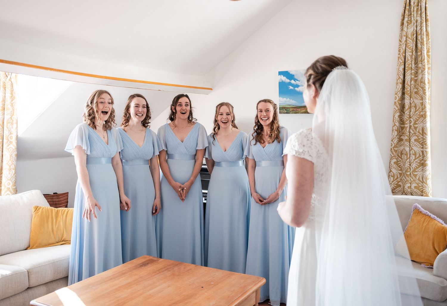 A group of bridesmaids wearing light blue dresses pose together in a collage of candid wedding photos.