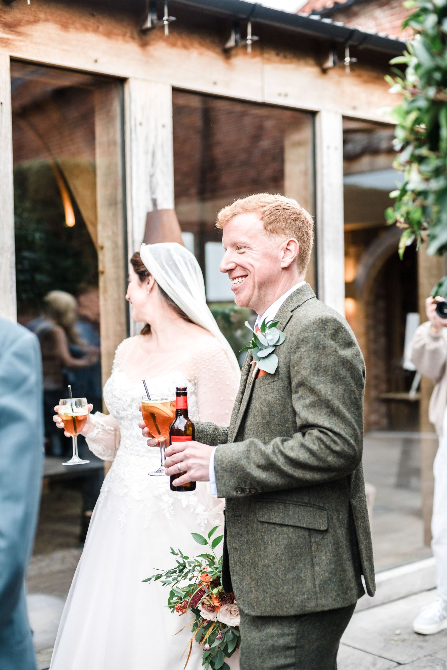 Wedding celebration at rustic venue with drinks and greenery.