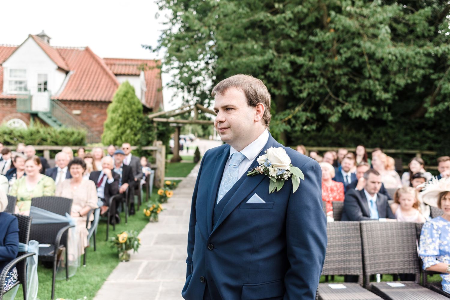 An emotional wedding ceremony moment in an outdoor garden setting.