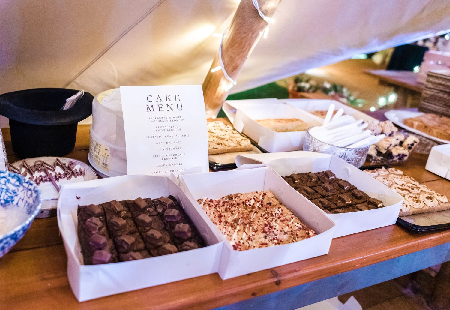 Display of chocolate truffles and desserts with a cake menu card at a wedding reception.
