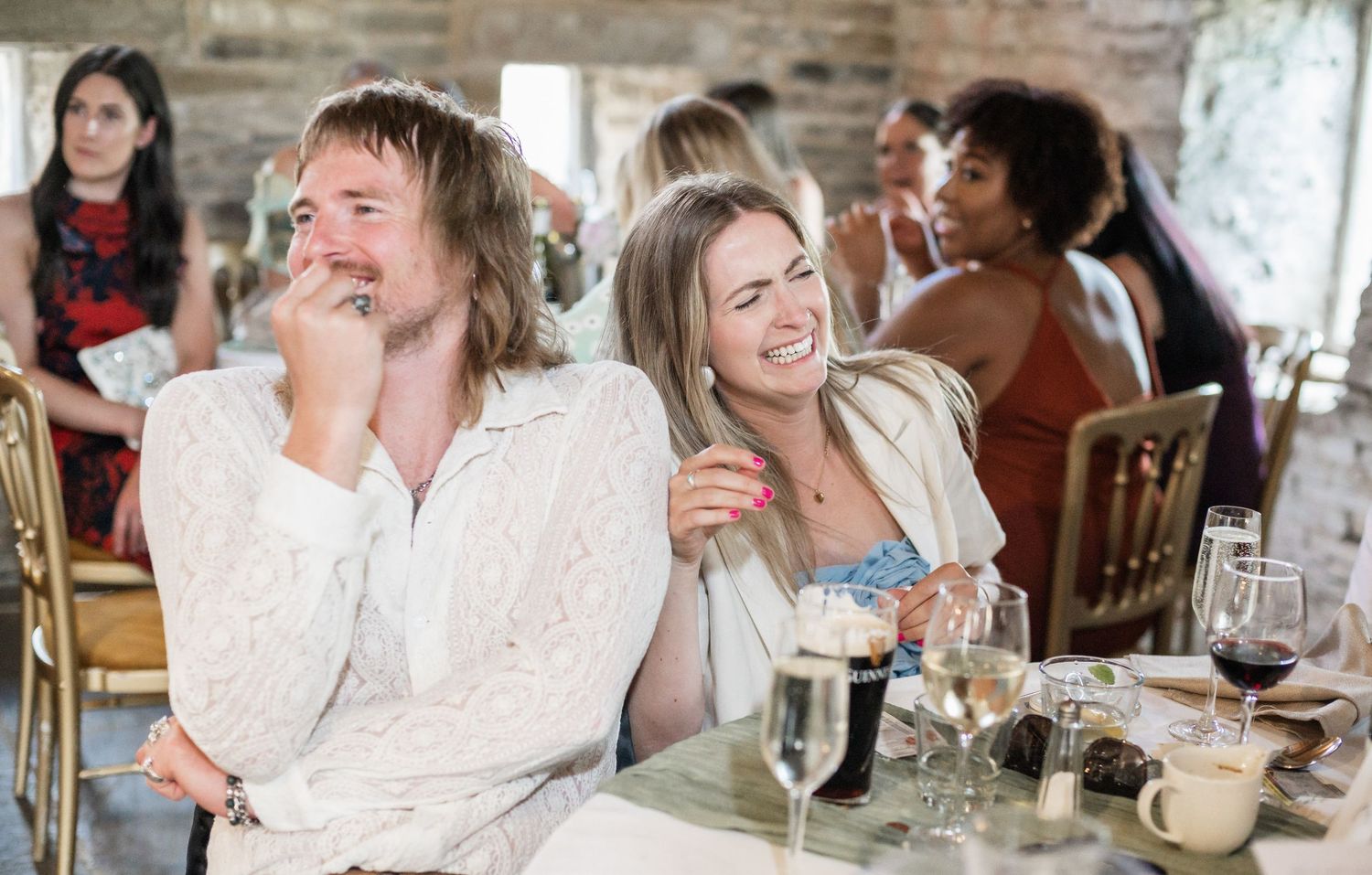 Guests laughing while enjoying a festive celebration at a wedding reception.