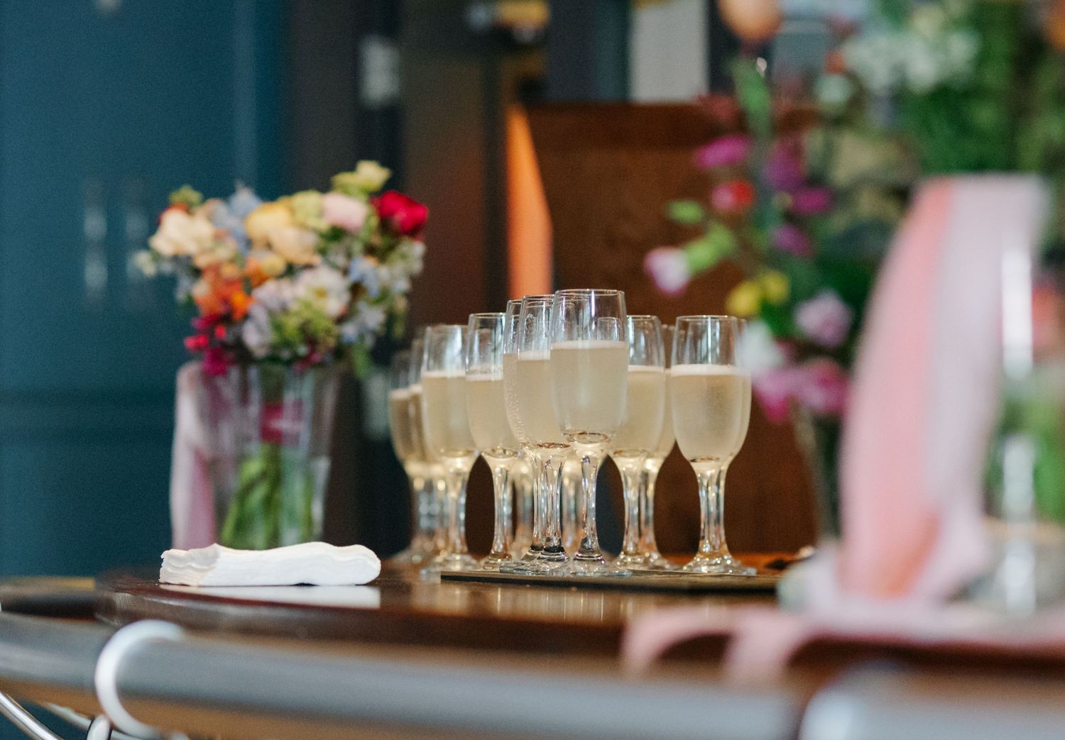 Reception table setting with elegant glassware and dark blue accents.