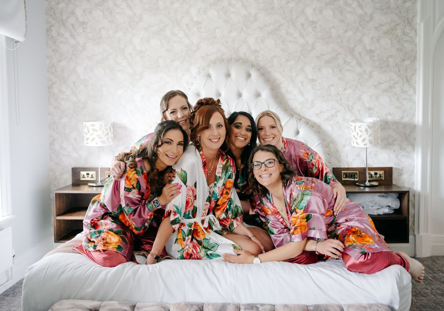 A group of people lying on bed wearing blankets arranged in series of four similar photos.