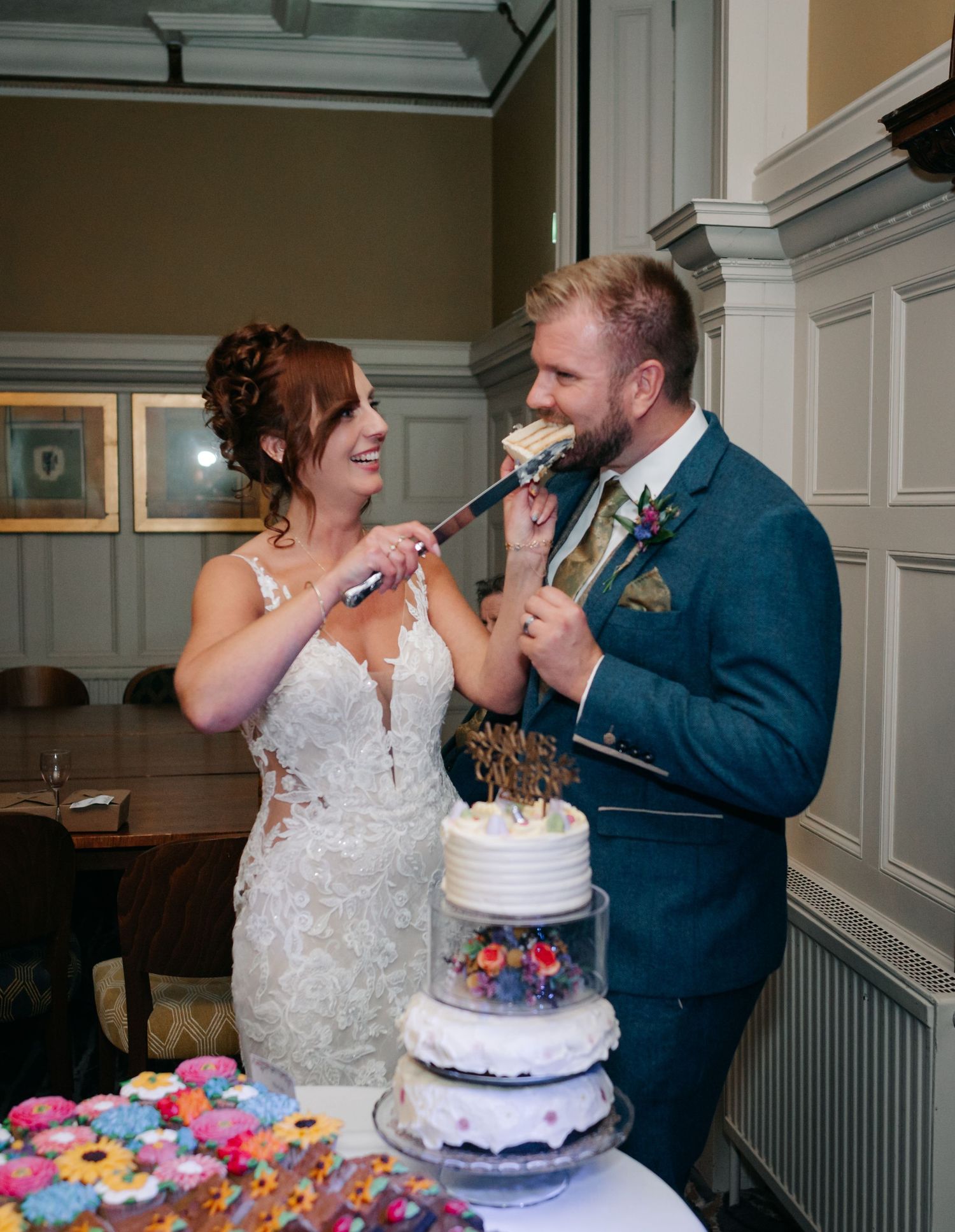Wedding couple feeding each other cake during their reception celebration.