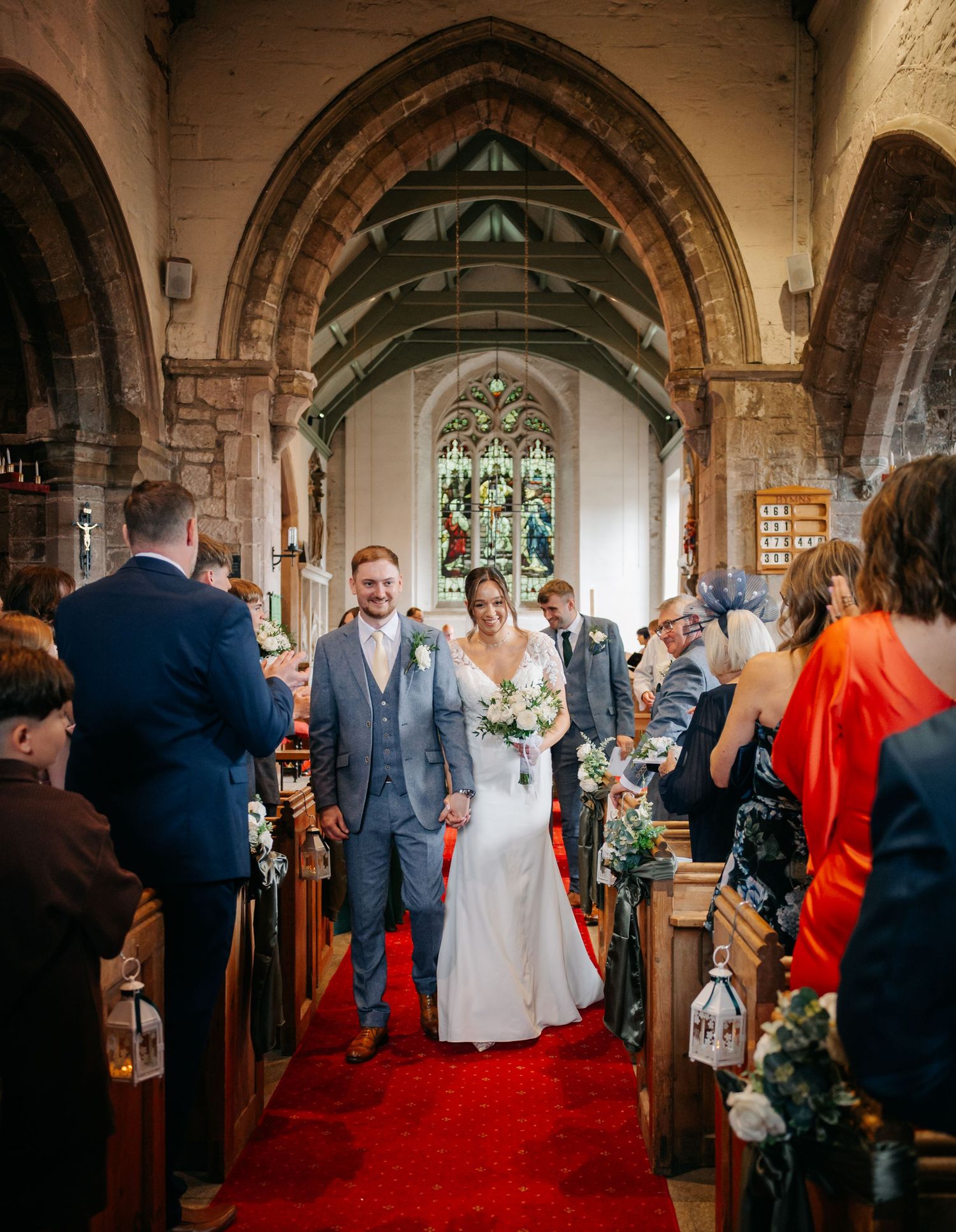 Wedding ceremony moments captured in a beautiful historic church with red carpet aisle.