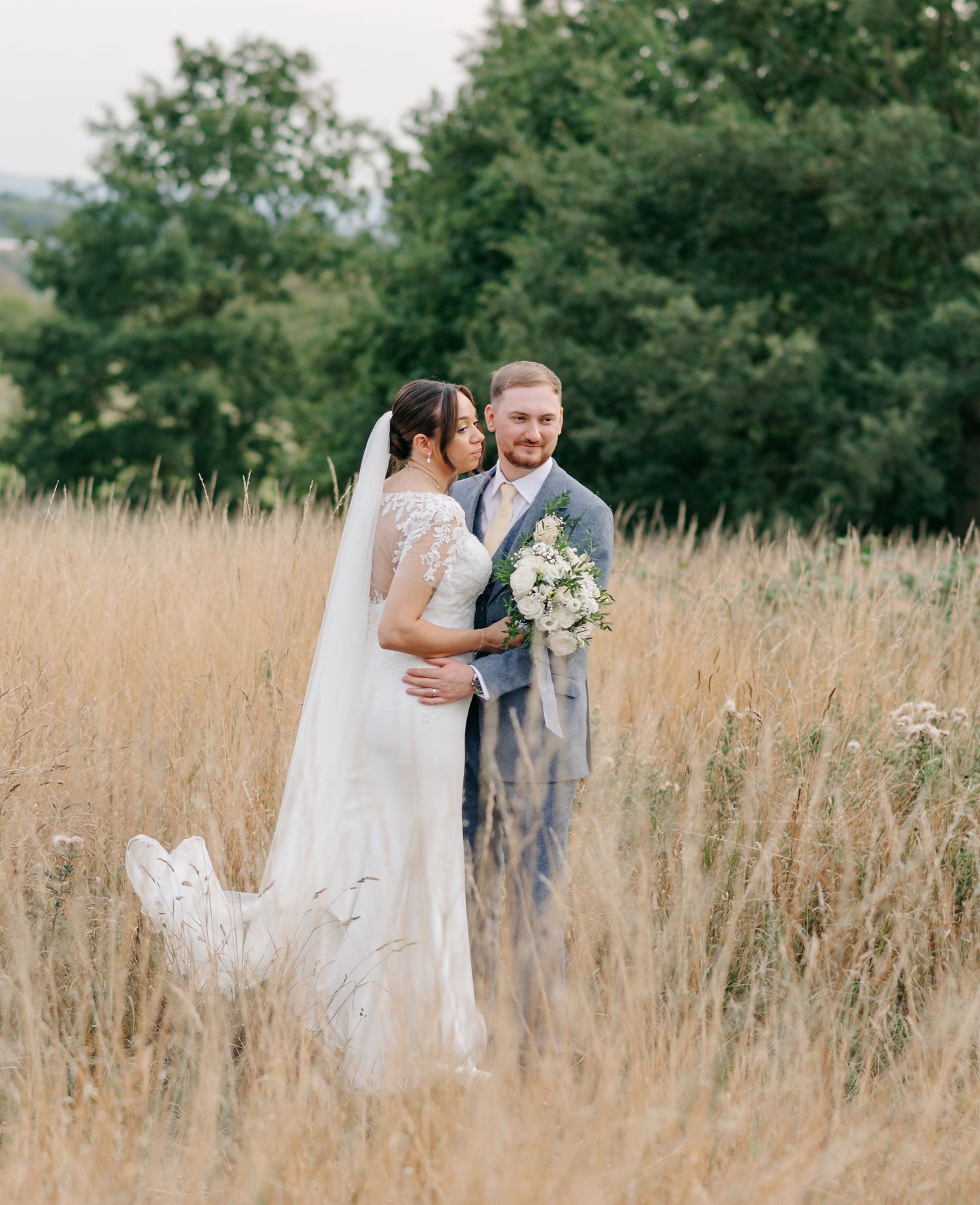 Romantic wedding couple embracing in a golden wheat field on their special day.