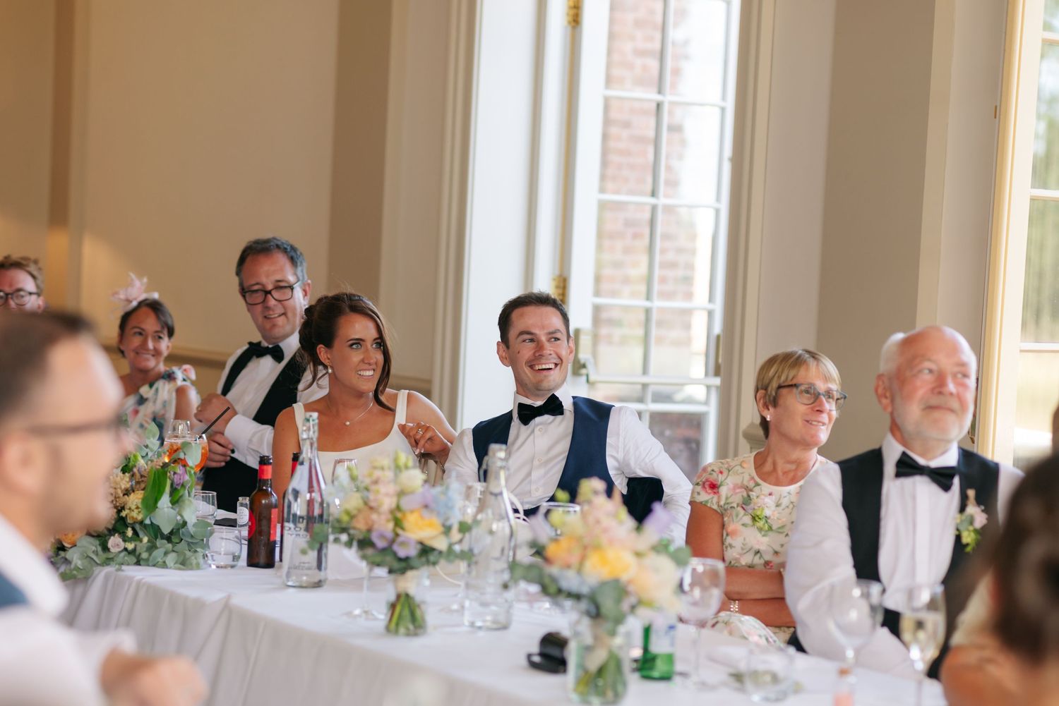 Wedding reception guests seated at tables enjoying a celebratory meal.