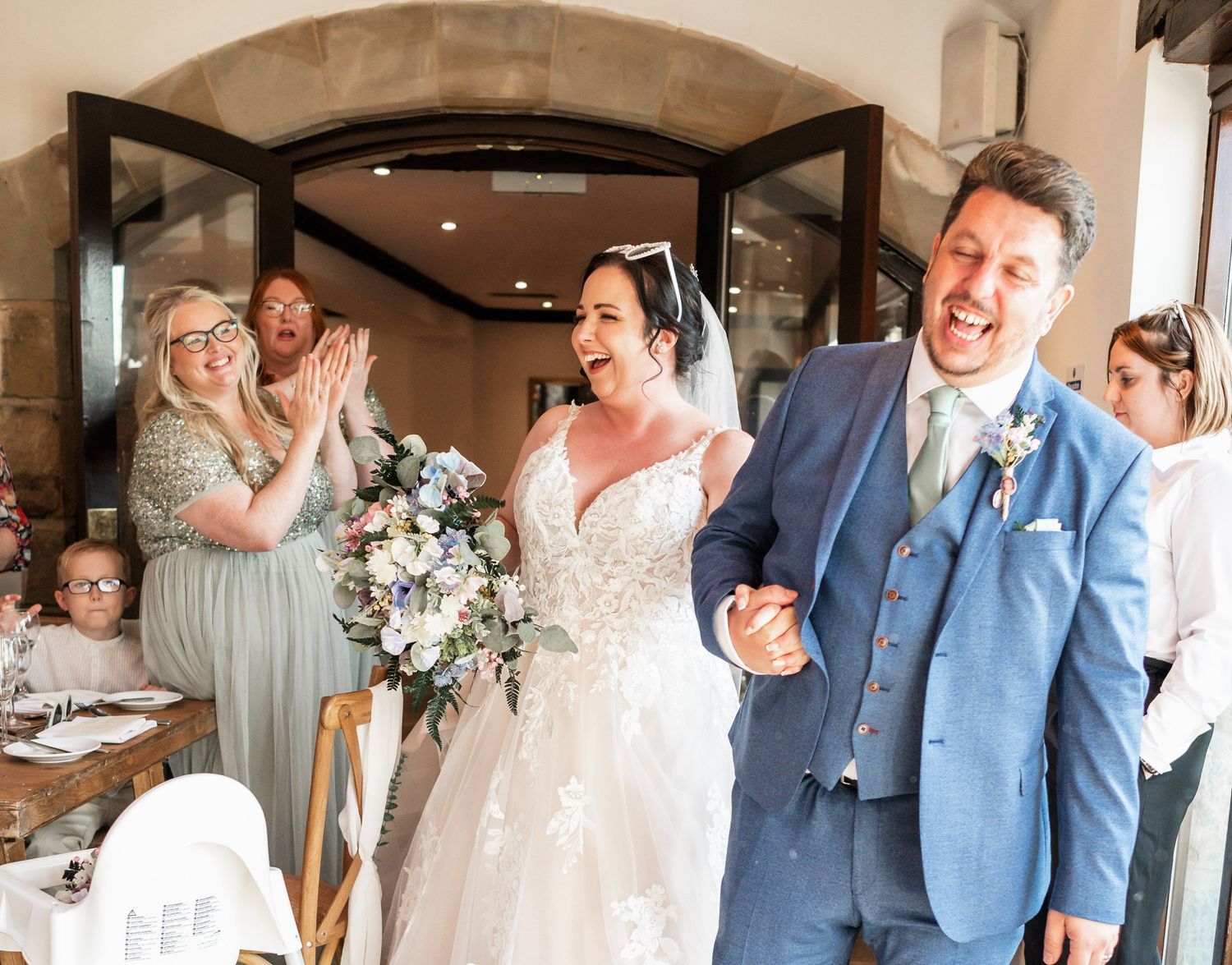 Wedding celebration moment with guests applauding inside reception venue.