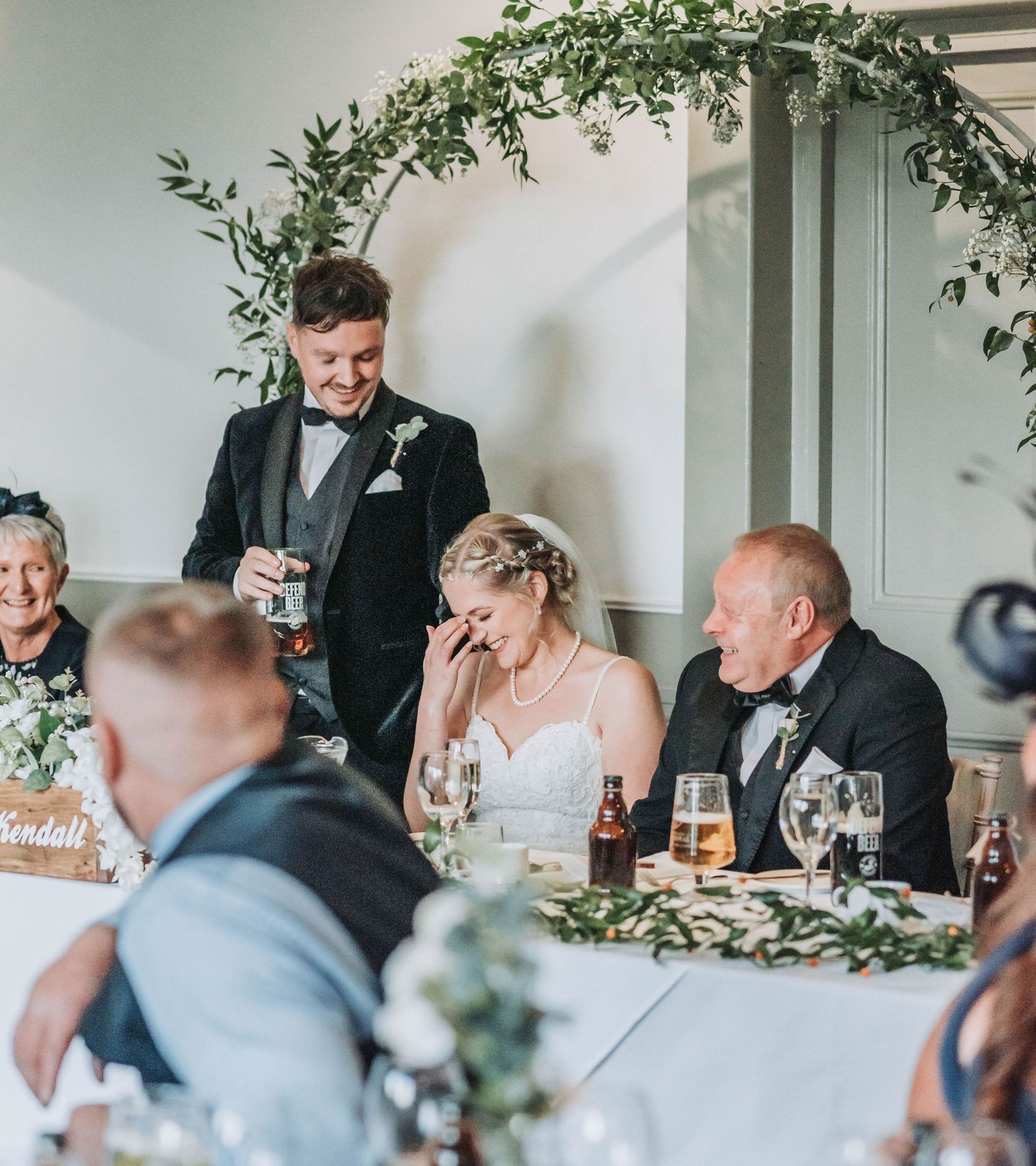 Reception dinner speech captures emotional moment at elegantly decorated wedding head table.