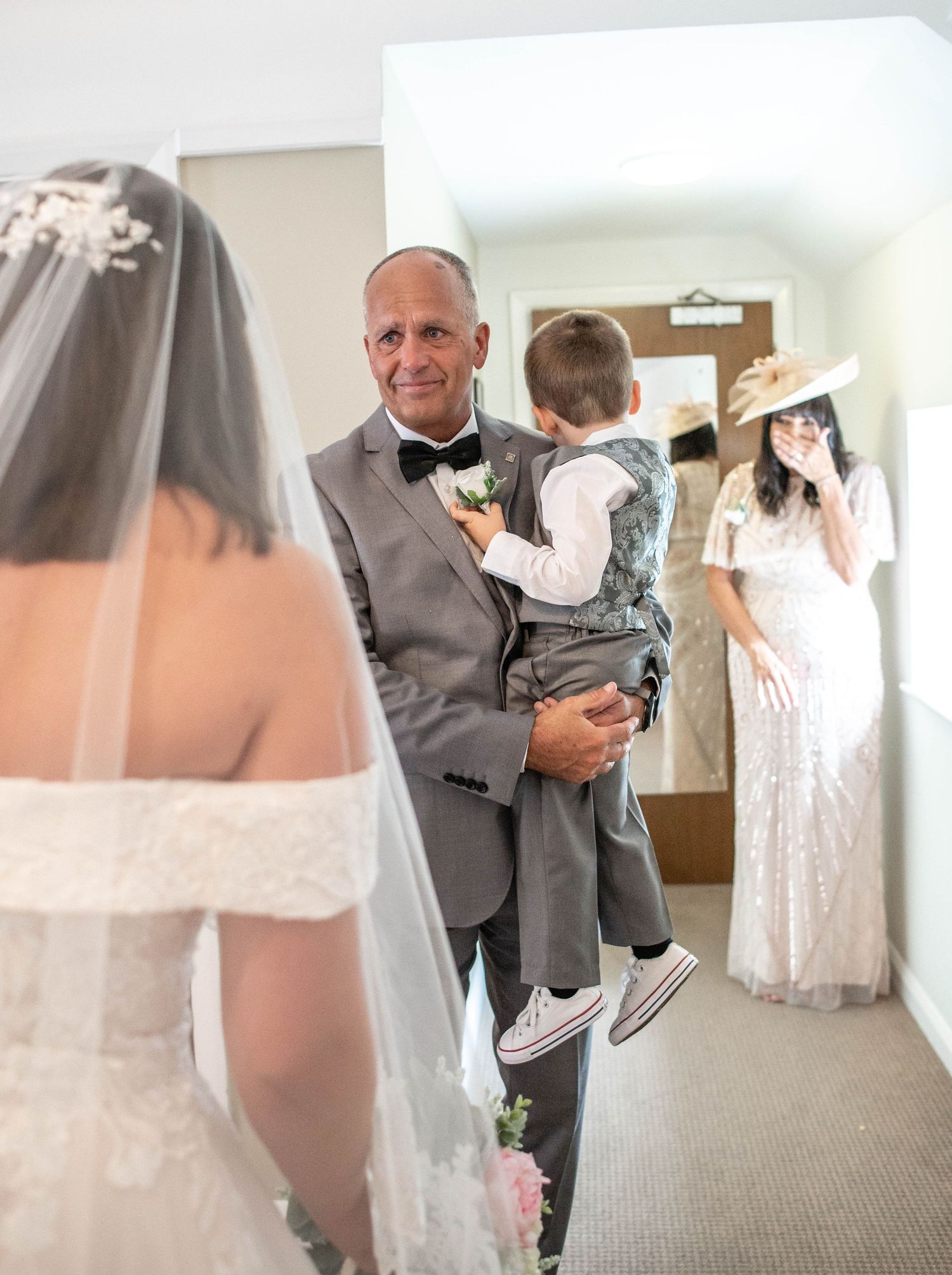 An emotional first look moment in a hallway before the wedding ceremony.