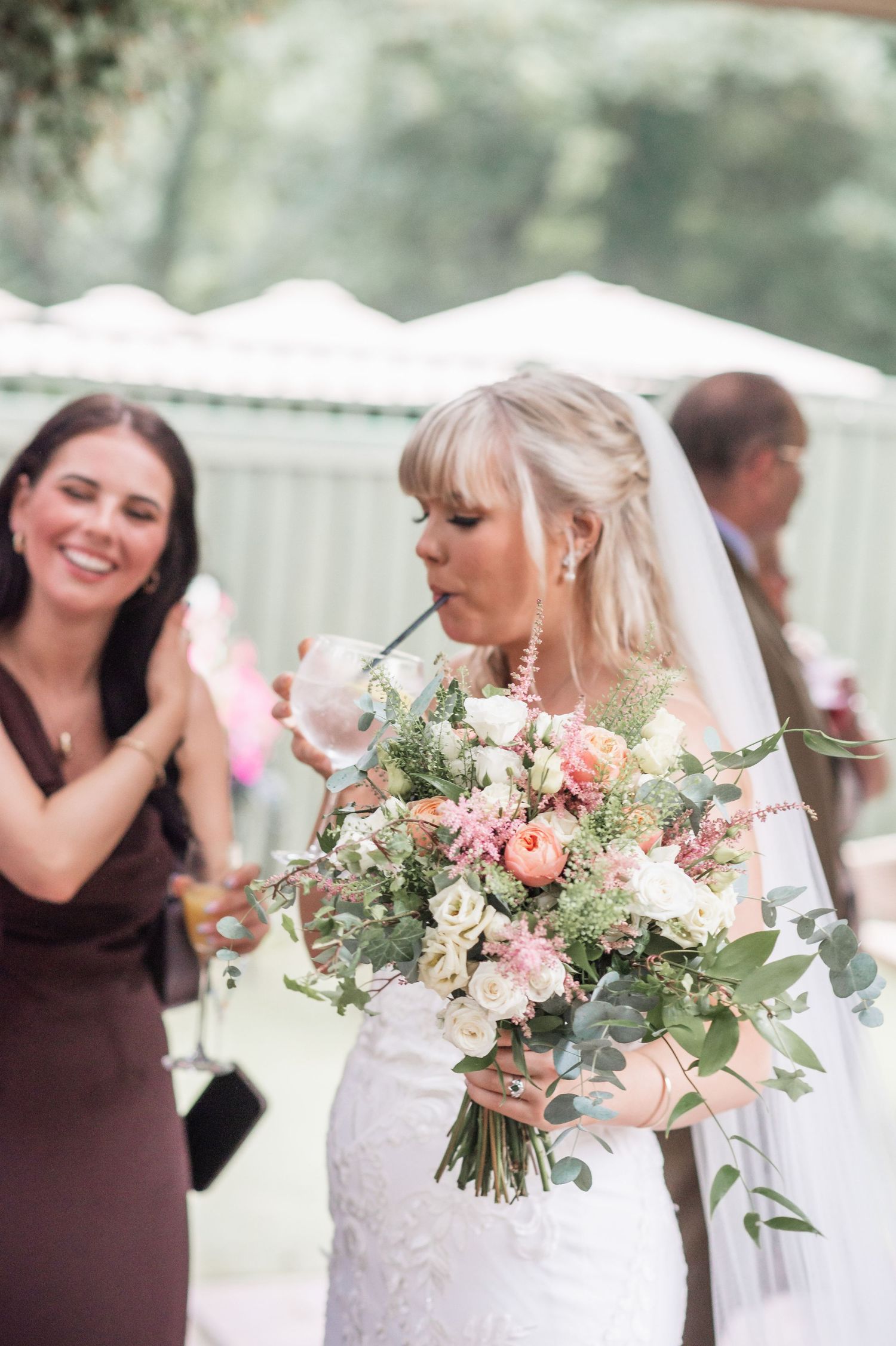 Wedding celebration scene with beautiful floral bouquet in natural outdoor setting.