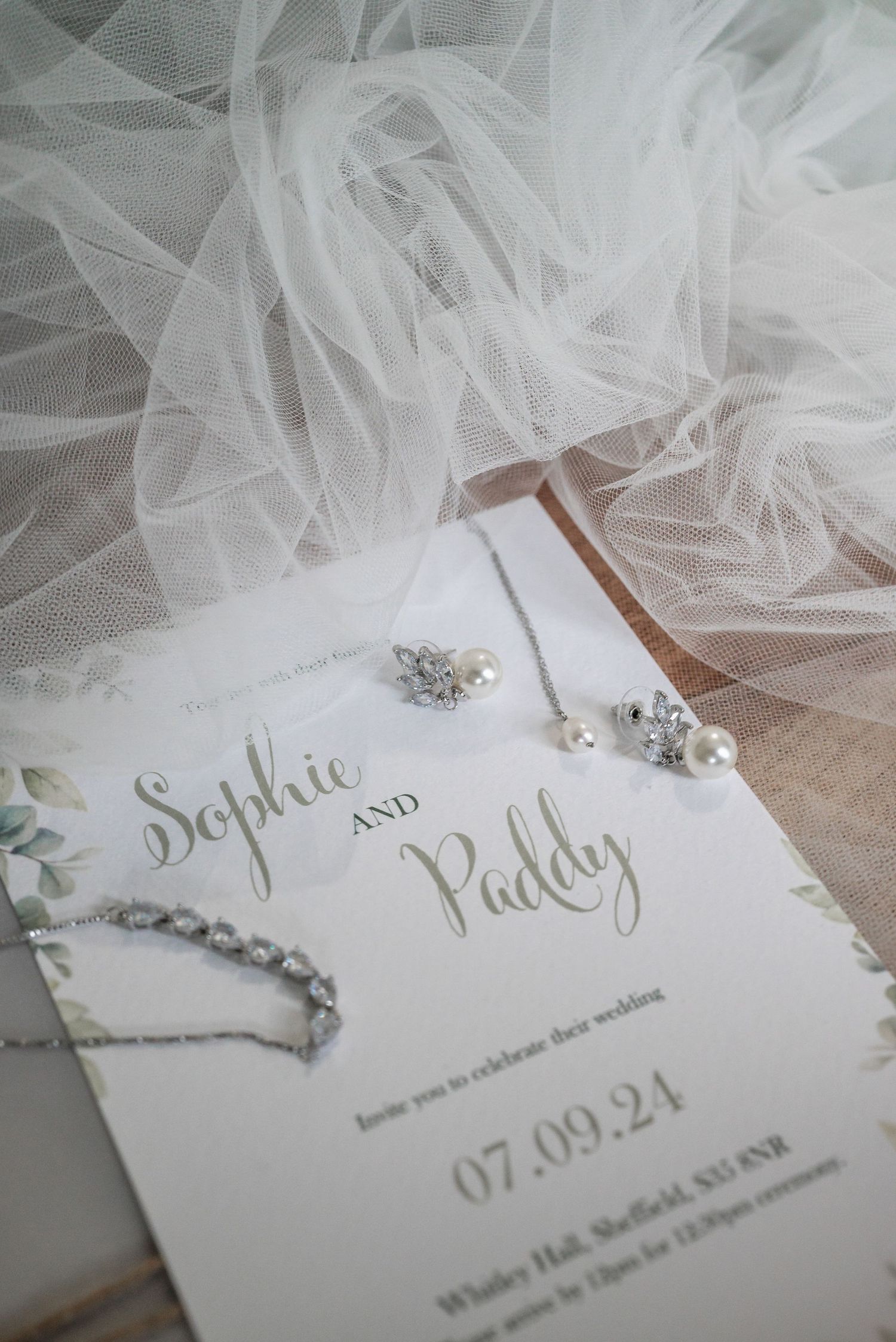 Elegant wedding invitation for Sophie and Paddy with delicate veil and jewelry details.