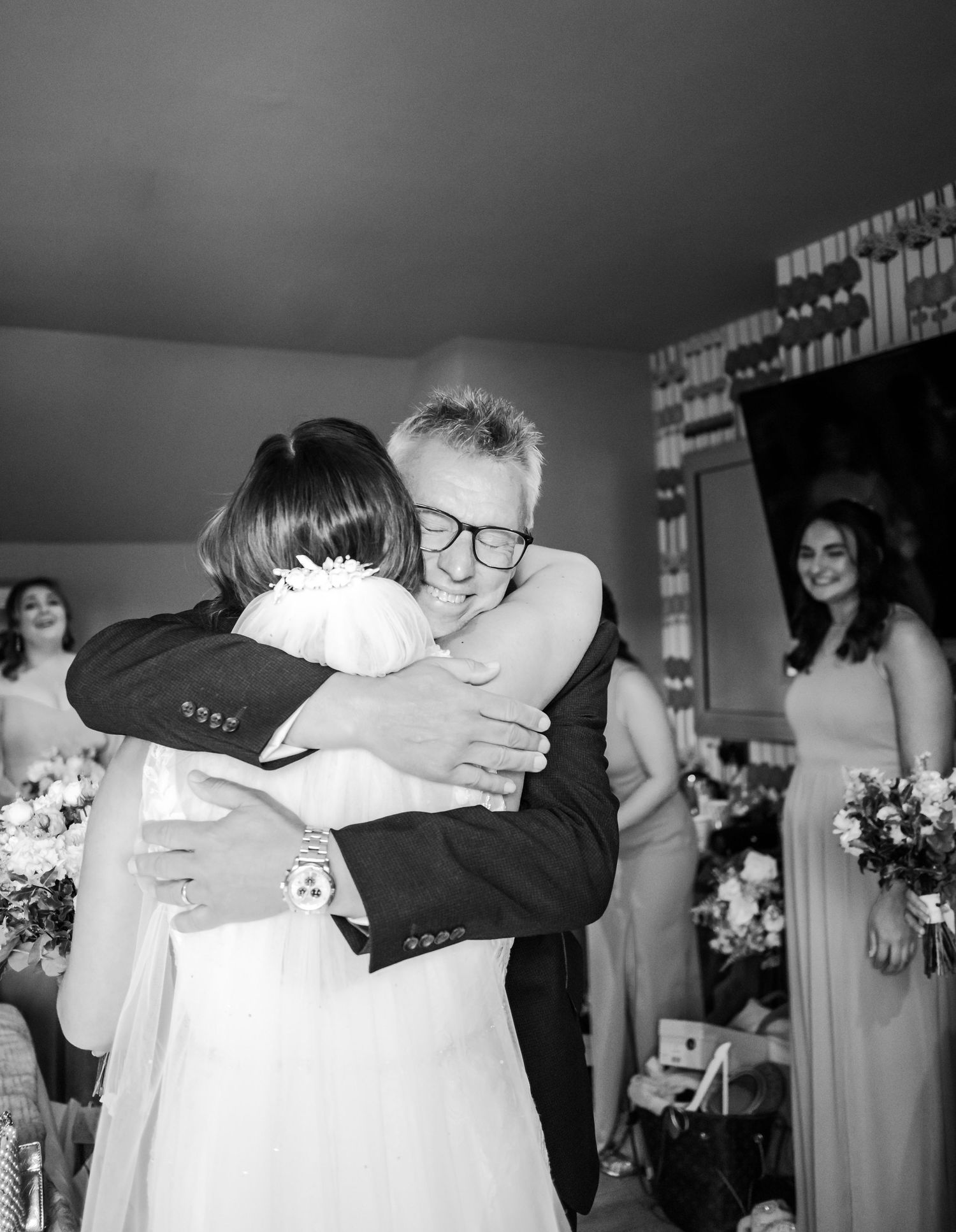 Black and white series of emotional embrace moments during wedding preparations.