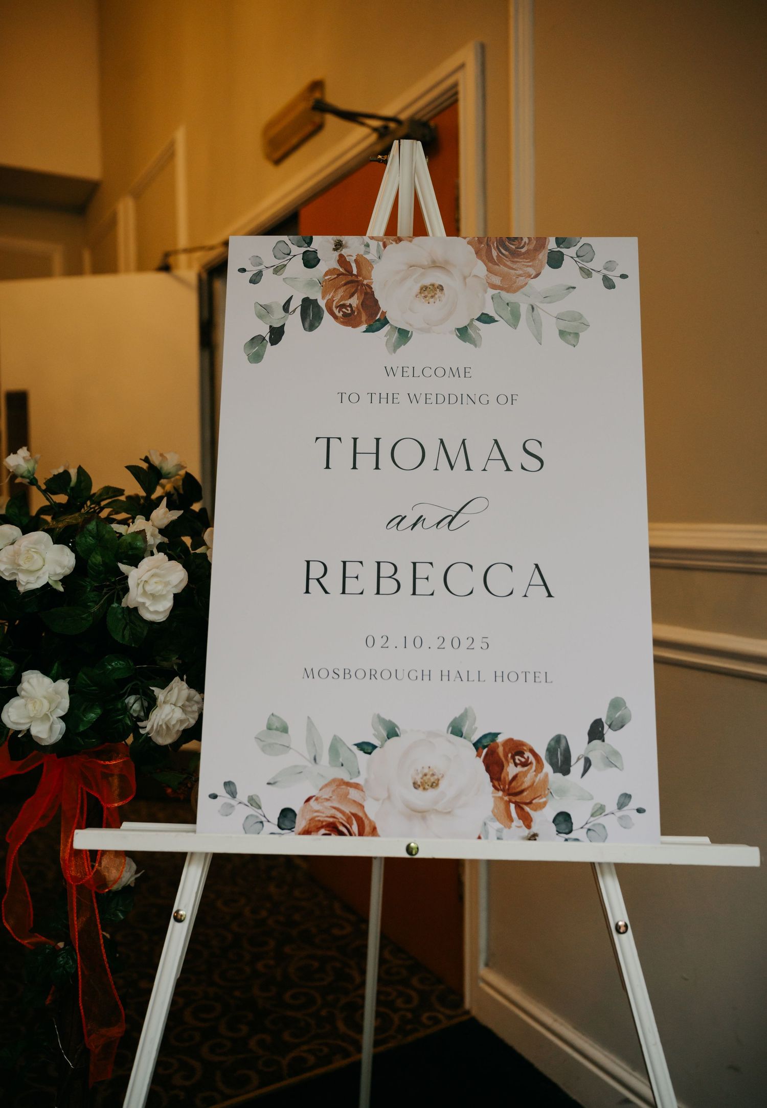Elegant wedding welcome signs displayed on white easels with floral designs.