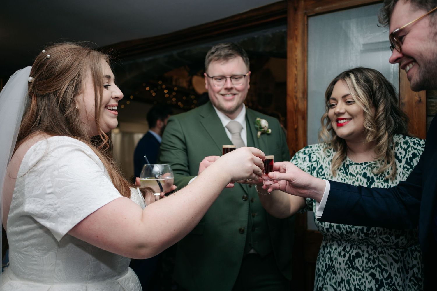 A celebratory moment shared between wedding guests during an indoor reception.
