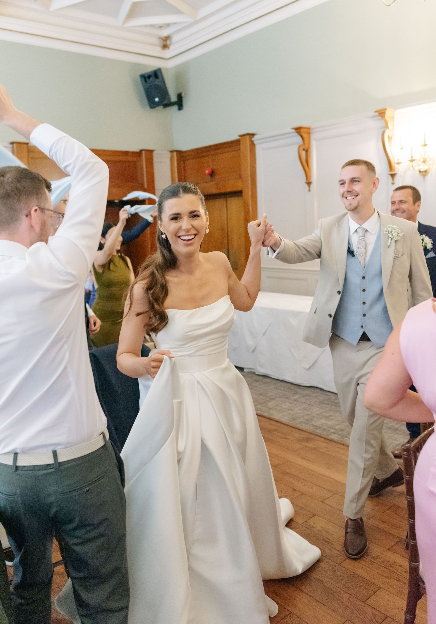 Wedding reception dance floor filled with celebrating guests in formal attire.