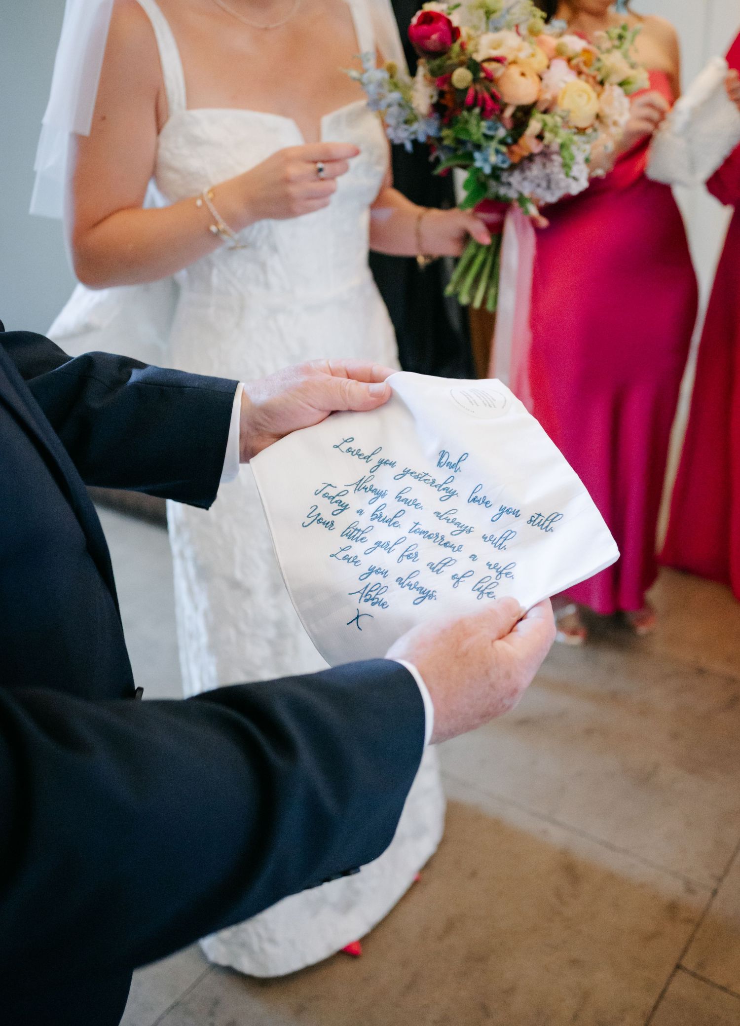 Closeup shots of hands holding handwritten wedding notes with bridesmaids in pink dresses visible in background.