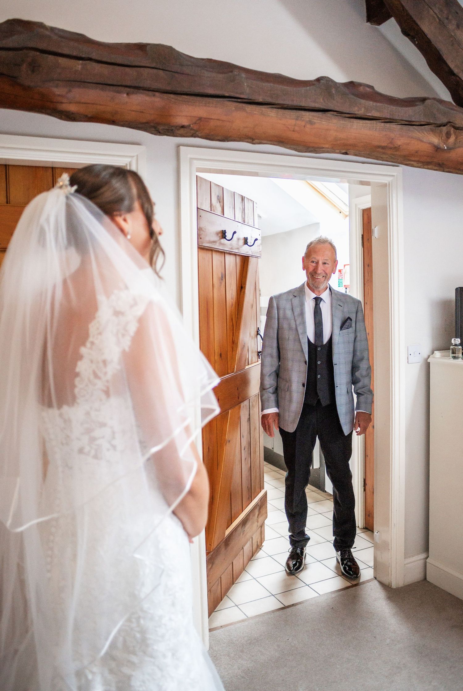 A wedding dress reveal moment in a rustic room with exposed wooden beams.